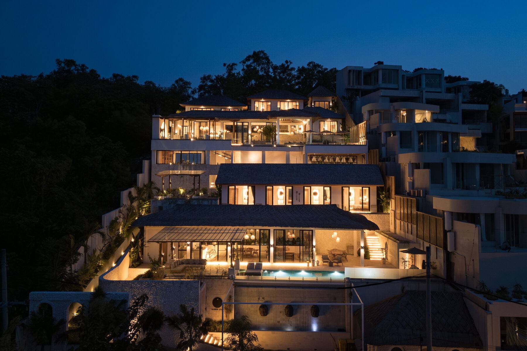 The Maison Ulu estate at golden hour — two villas, one hillside.